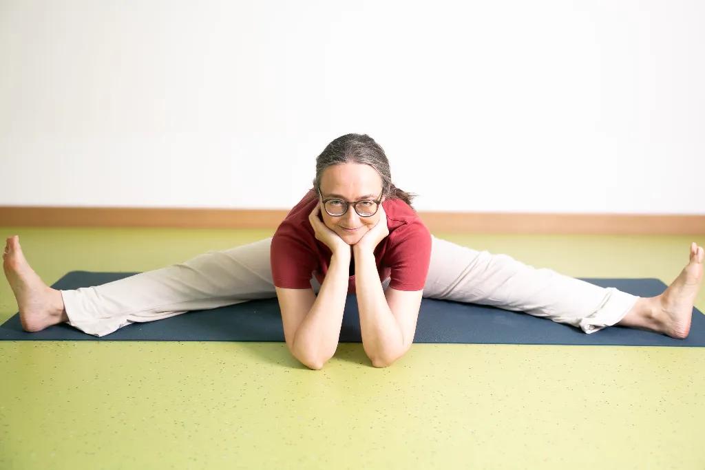Sitzende Grätsche mit Händen auf dem Boden