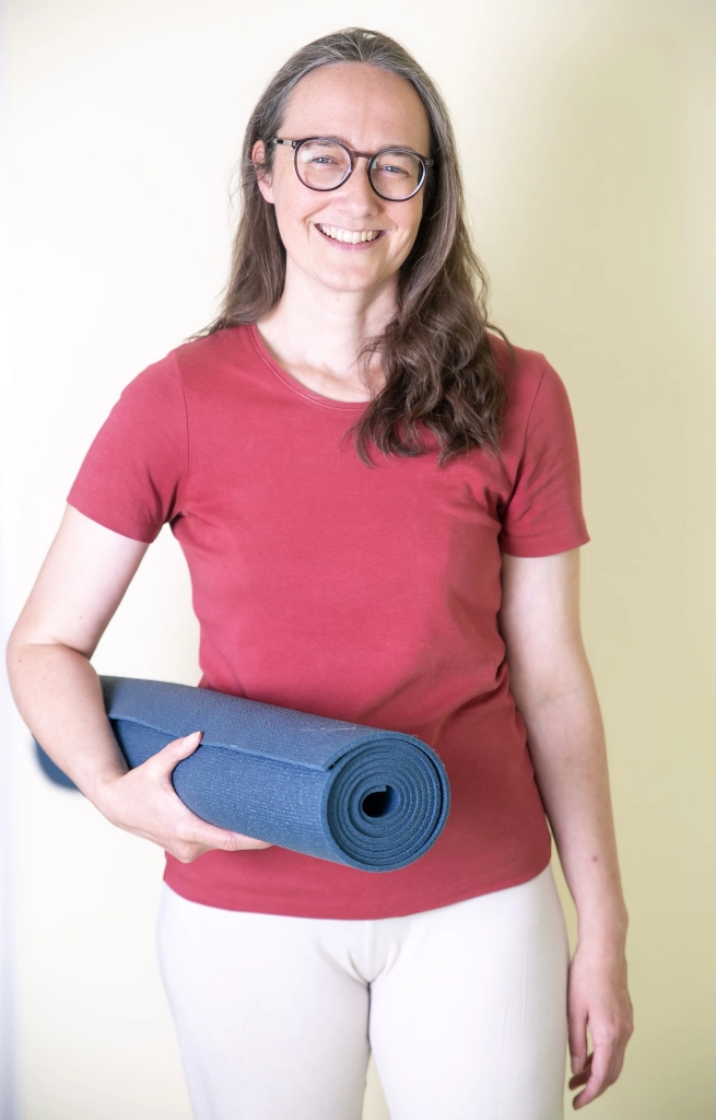 Anmeldung Yoga. Sandra Roth mit der Yogamatte